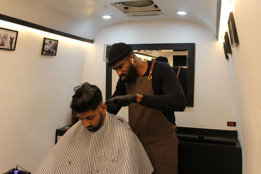 Photo of a man doing haircut to another a man 